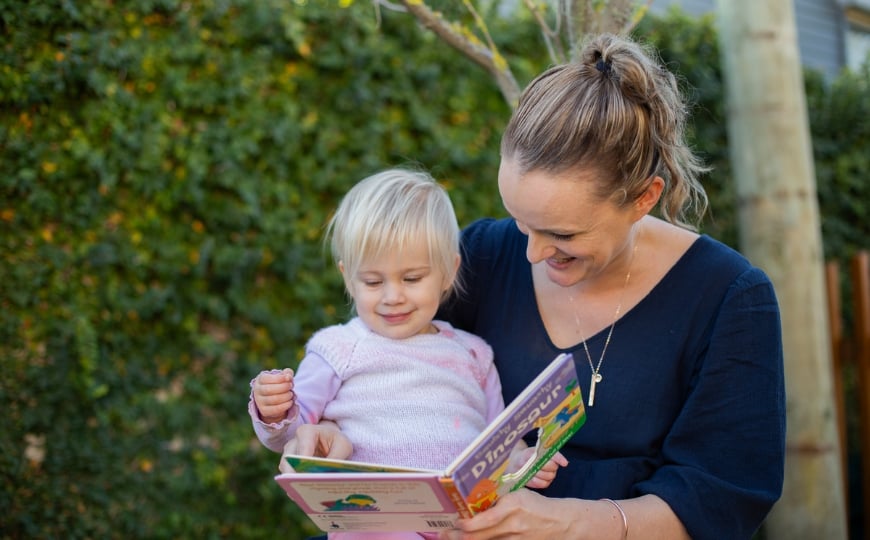 kindercare-palmerston-north-teacher-toddler-reading-book-literacy-language-development